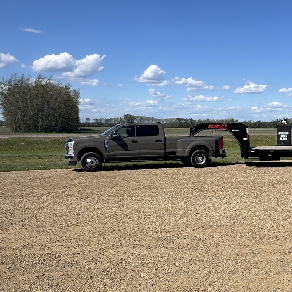 Talico Ventures one-ton dually truck hitched to a 30-foot gooseneck flatdeck trailer